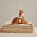 Deer figurine on a stack of books with a textured wall background