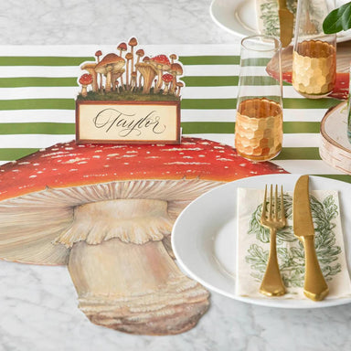 Table setting with mushroom-themed place card and striped tablecloth