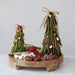 Decorative Christmas trees made of branches and twigs on a wooden board with food items.