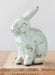 Vintage-style ceramic rabbit on a wooden surface with a light background