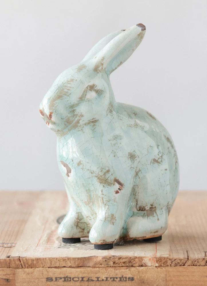 Vintage-style ceramic rabbit on a wooden surface with a light background