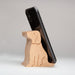 A black smartphone propped upright in a light natural wood dog-shaped stand on a clean light gray studio background.