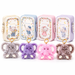 Four rectangular metal lunch boxes in cream, blue, pink, and lavender, each decorated with a floral border and an elephant illustration, shown with matching plush elephant keychains in gray, purple, pink, and brown below them on a white background.