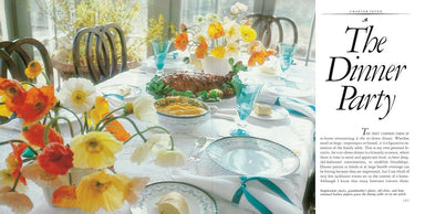 Dinner party setup with colorful flowers and tableware on a table.