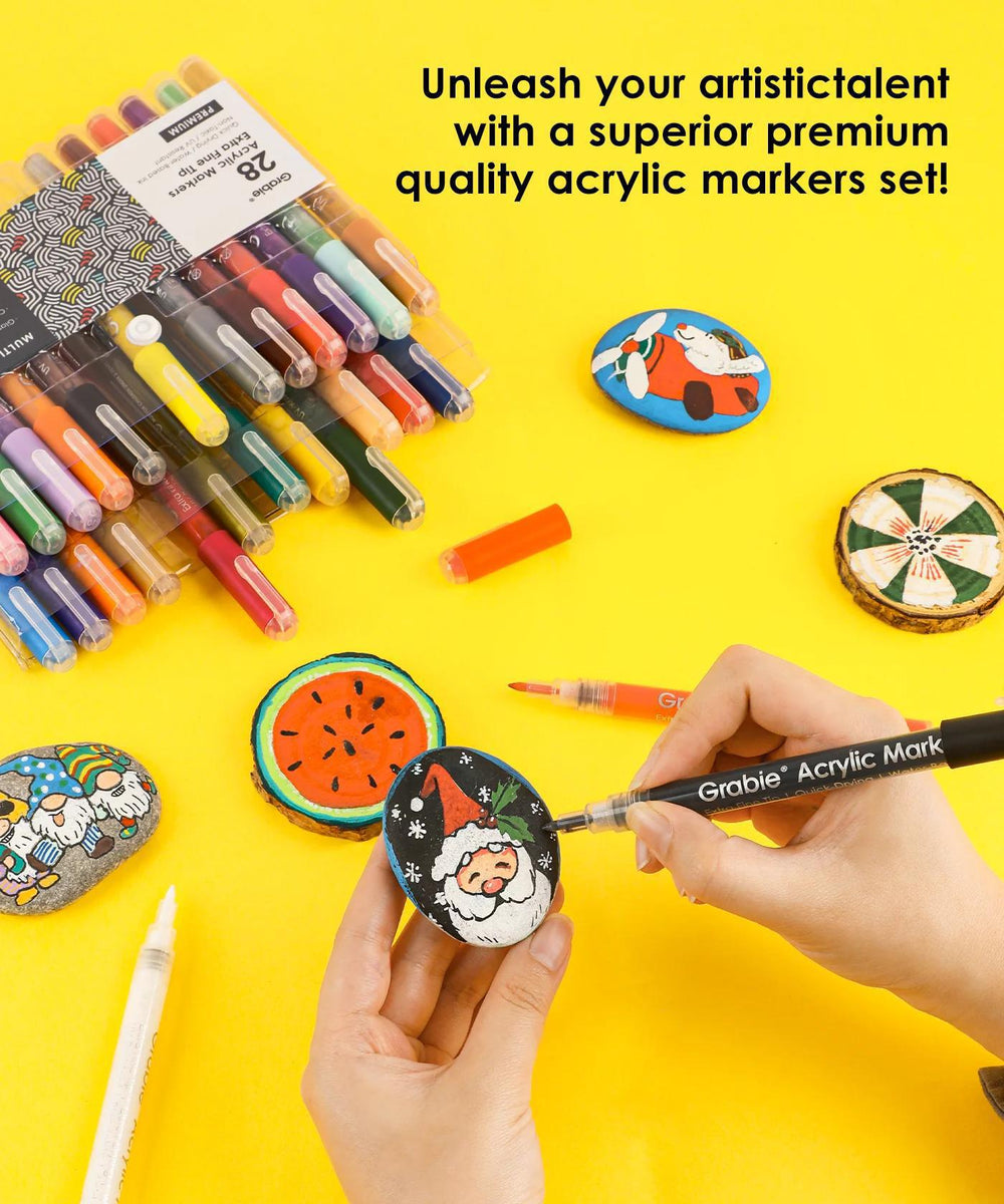 Acrylic markers set with decorated rocks on a yellow background