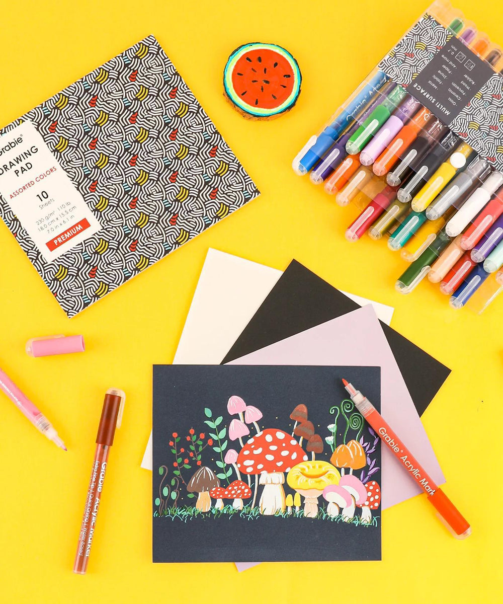 Coloring supplies including markers, paper, and a completed artwork on a yellow background