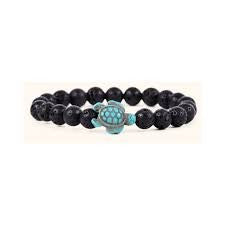 A beaded stretch bracelet featuring matte black round beads and a central turquoise-colored turtle charm with a textured pattern, set against a plain white background.
