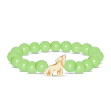 A beaded stretch bracelet featuring light green round beads and a small carved cream-colored dog charm in the center, displayed on a clean white background.