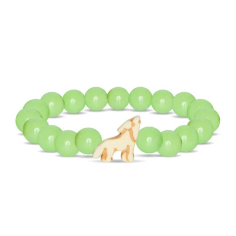 A beaded stretch bracelet featuring light green round beads and a small carved cream-colored dog charm in the center, displayed on a clean white background.