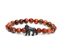 A beaded stretch bracelet featuring round brown and orange marbled beads with a small black dog-shaped charm in the center, shown on a plain white background.