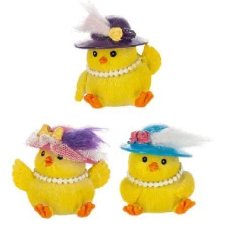 Three small yellow chicks with decorative hats on a white background