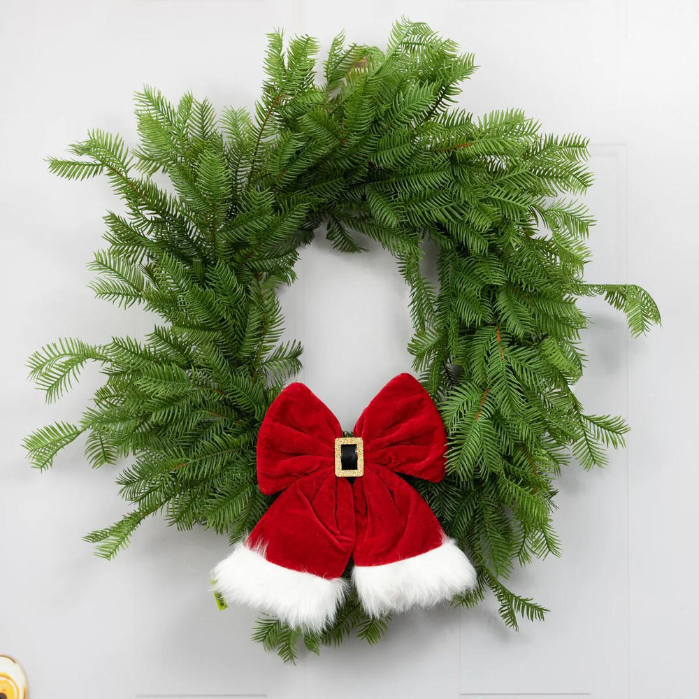 Christmas wreath with a red bow and white trim on a light gray background