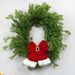 Christmas wreath with a red bow and white trim on a light gray background