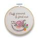 Embroidery hoop with a cat and yarn design and text 'Fluff around & find out' on a white background