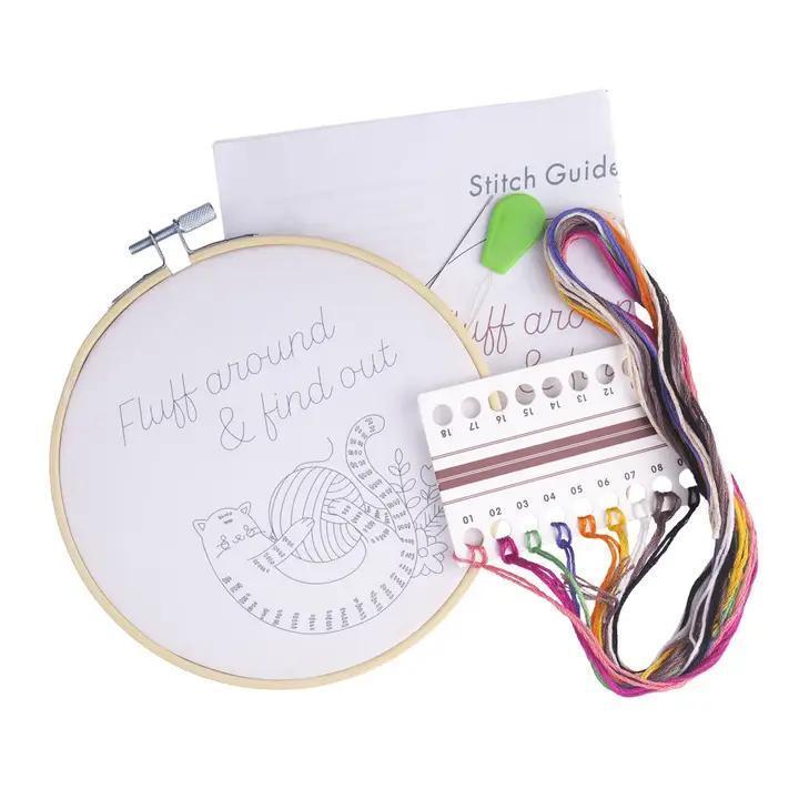 Embroidery hoop with pre-printed design, thread, and stitch guide on a white background