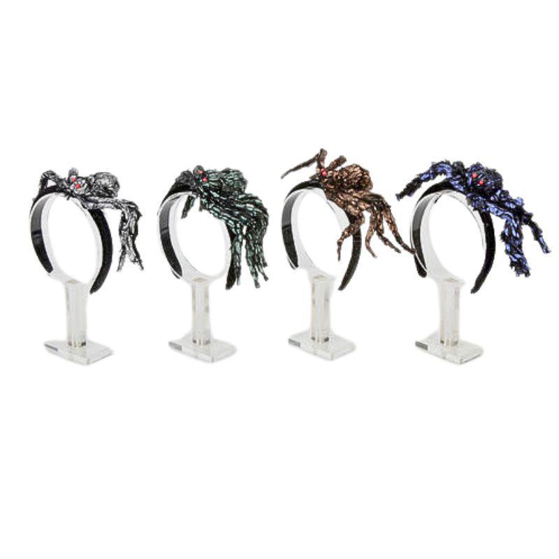 Four spider-themed headbands on stands against a white background