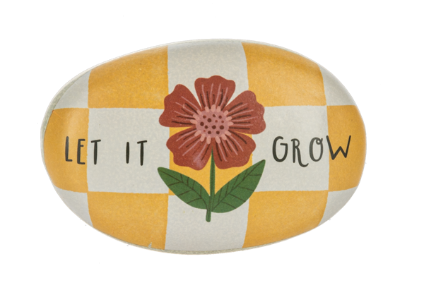 Decorative stone with a flower design and text 'Let It Grow' on a checkered background