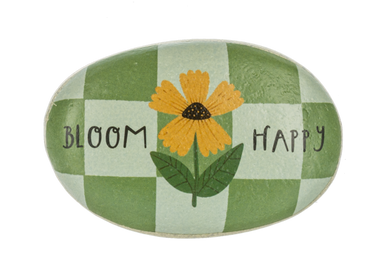 Decorative stone with a yellow flower and text 'Bloom Happy' on a green and white checkered background