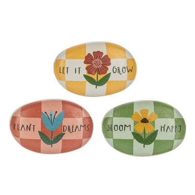 Three decorative stones with floral illustrations and motivational phrases on a white background