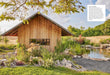 Wooden cabin in a natural setting with a pond and trees