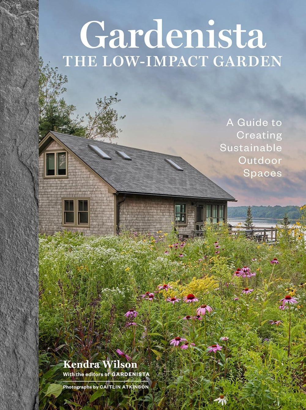 Book cover of 'The Low-Impact Garden' by Kendra Wilson with a scenic house and garden.