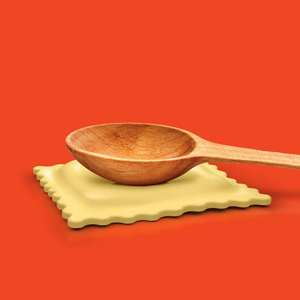 Wooden spoon on a green napkin against an orange background