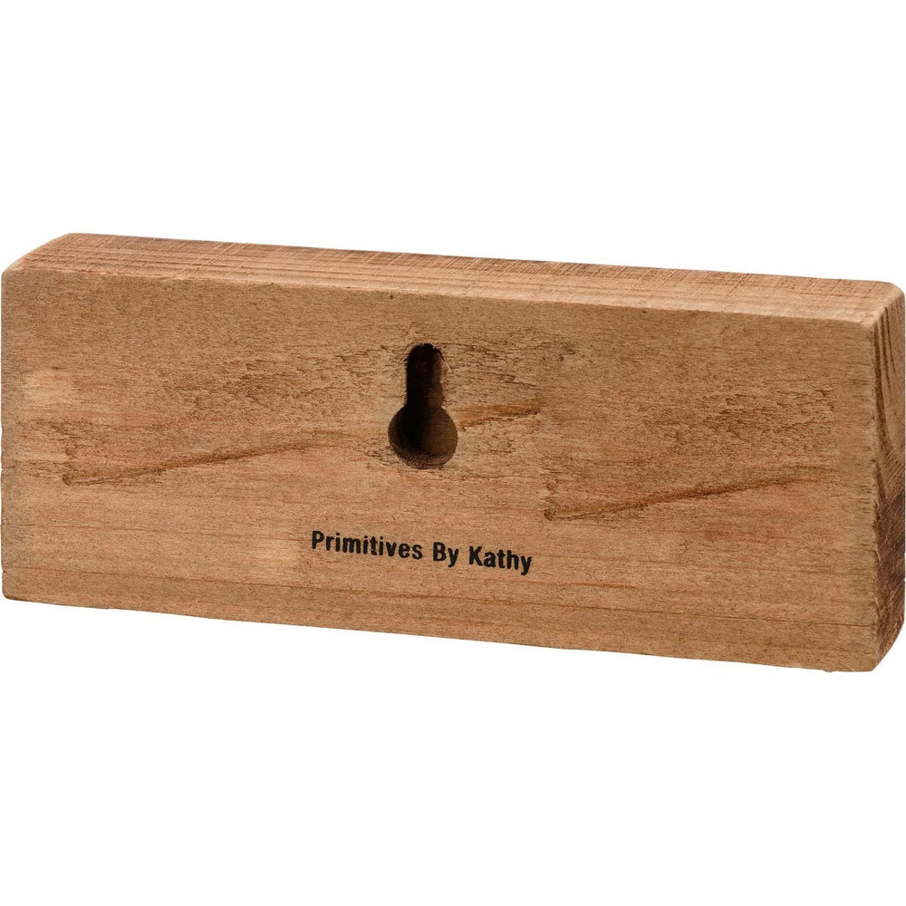 Wooden block with a hole and 'Primitives By Kathy' branding on a white background