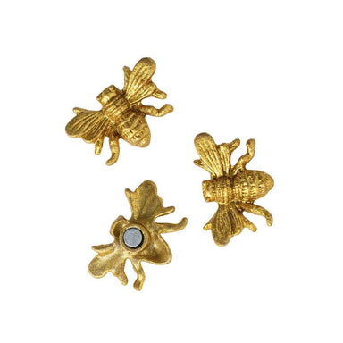 Three gold bee-shaped objects on a white background