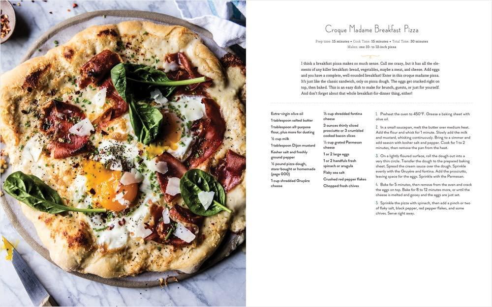 Pizza with toppings on a marble surface next to a recipe card.