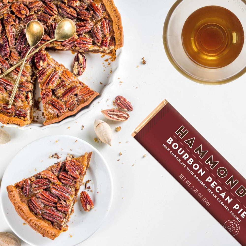 Pecan pie with a slice on a plate, a glass of tea, and a Hammond Pecan Pie bar packaging.