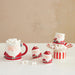 Set of Santa Claus-themed mugs and containers with marshmallows on a beige background