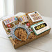 Gift box with decorative items including a headband, mug, and cards on a light surface.