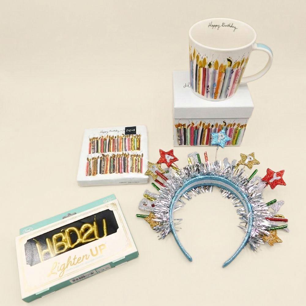 Collection of birthday-themed items including a mug, cards, and decorative headbands on a beige background.