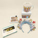 Collection of birthday-themed items including a mug, cards, and decorative headbands on a beige background.