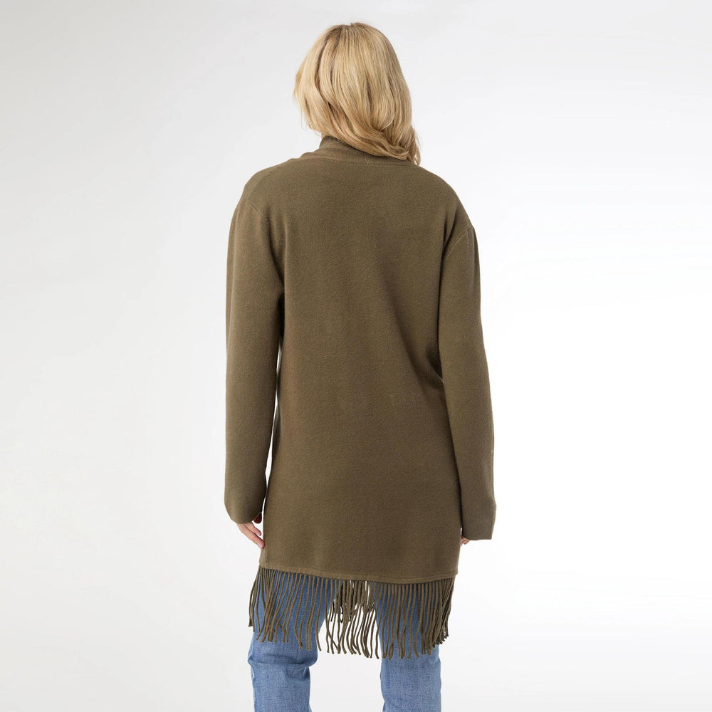 Person wearing a green cardigan with fringe details on a white background