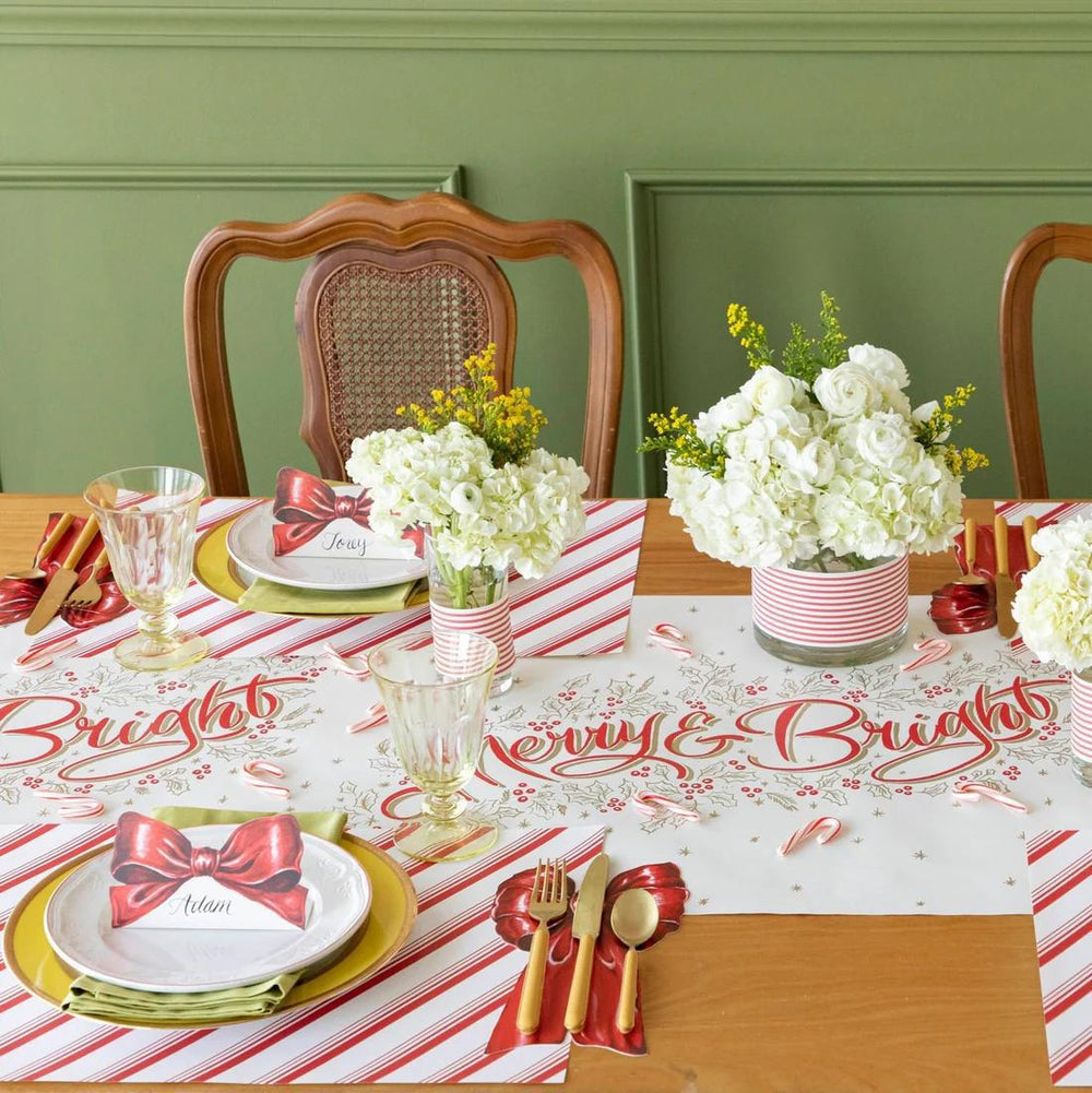 Decorative Christmas table setting with floral arrangements and festive tablecloth.