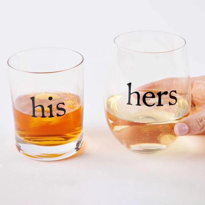 Two glasses labeled 'his' and 'hers' filled with liquid on a white background
