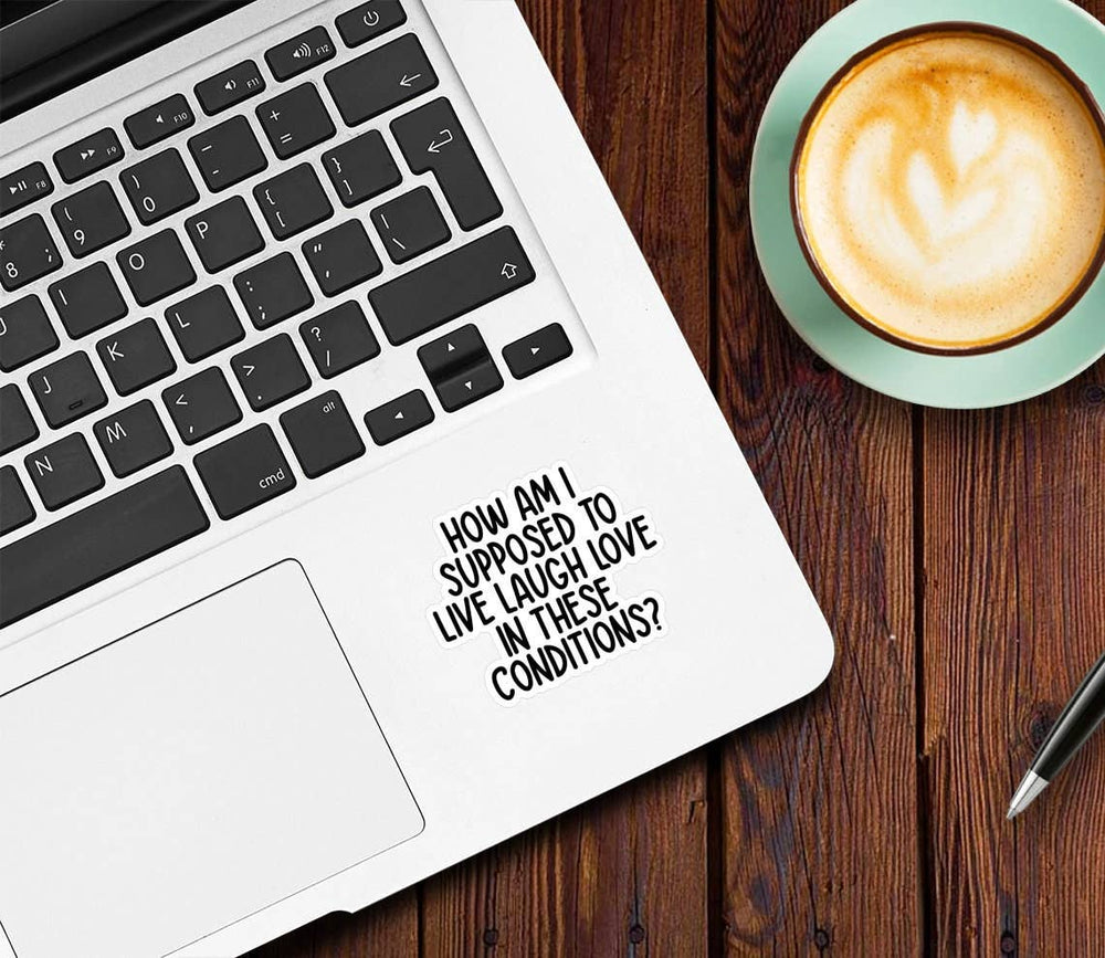 Laptop with a motivational quote on a wooden table next to a cup of coffee.