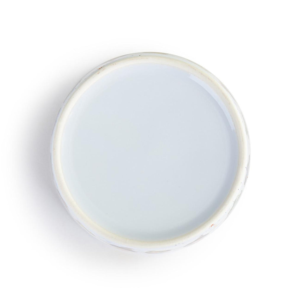 Round ceramic plate with a white interior and rim on a white background
