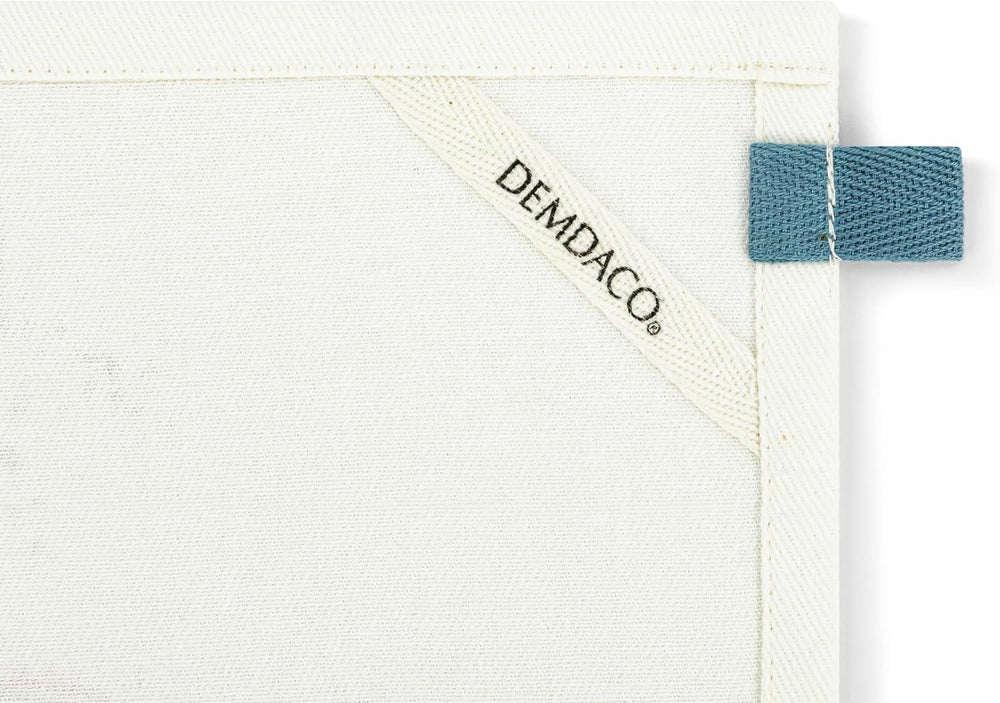 White textured surface with a blue tag and 'DEMDACO' branding.