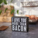 Small wooden block with 'I LOVE YOU MORE THAN BACON' text on a kitchen counter.