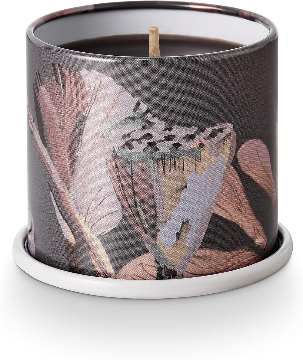 Candle in a decorative container with floral design on a white background