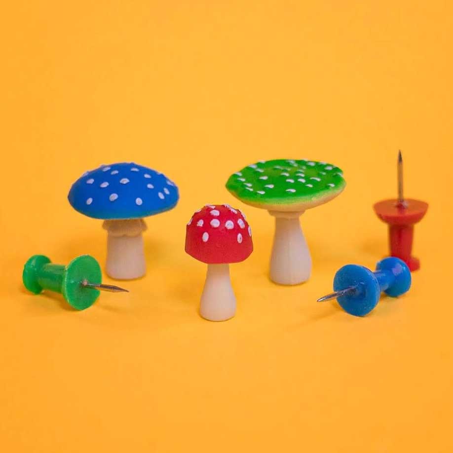 mushrooms plastic figurines on display next to  some push pins to show dimentions