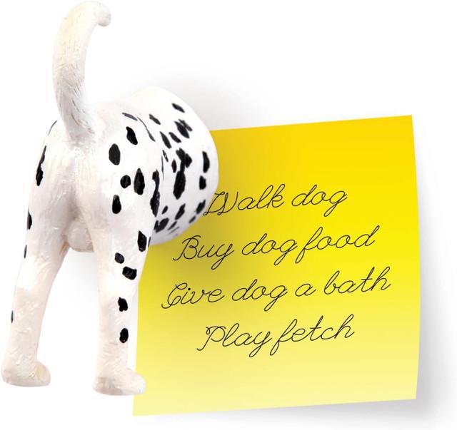Stuffed dalmatian dog toy next to a yellow notepad with text on a white background