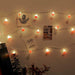 String lights on a wall with photos and cards attached