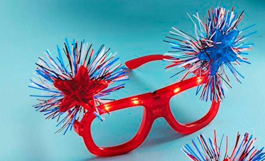 Red glasses with blue and red pom-pom attachments on a blue background