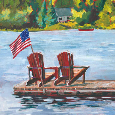 Two red Adirondack chairs on a dock with an American flag, surrounded by a lake and trees.