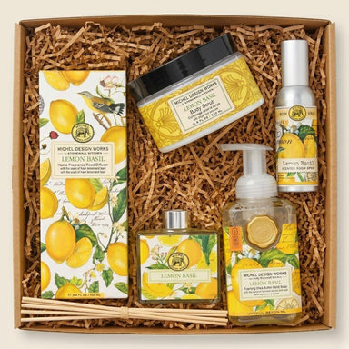 Gift set with lemon-themed products including soap, body scrub, and candles in a box.