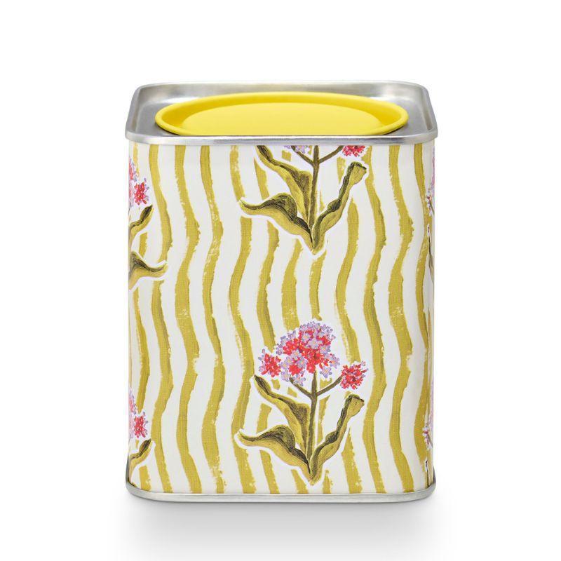 Decorative canister with floral design and yellow lid on a white background