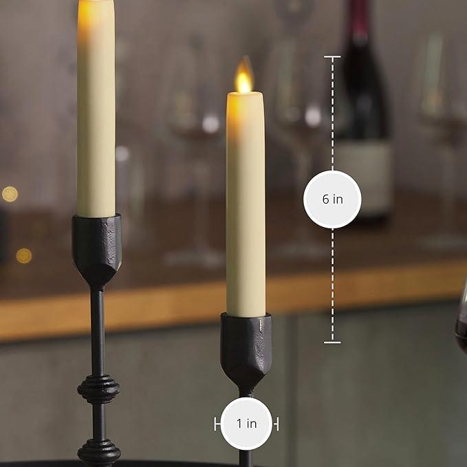 Two lit candles in black holders with measurements on a blurred background
